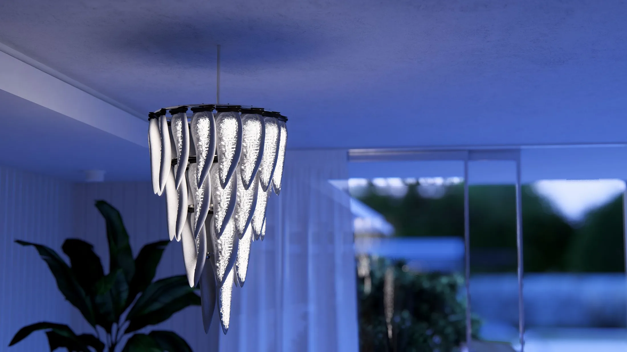 Tiered white chandelier hanging in a blue-lit interior